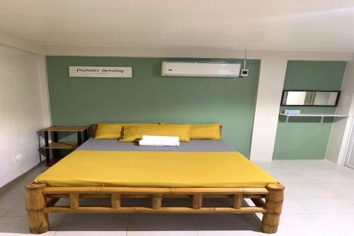 a bedroom with a bed with a yellow blanket at Michael's Homestay - Farm Villa near Patar Beach & Bolinao Falls in Bolinao