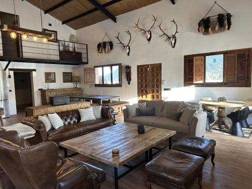 a living room with couches and tables and antlers on the wall at CasaBARA in Vélez Rubio