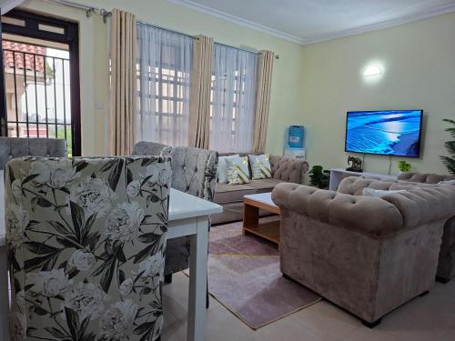a living room with a couch and a tv at Lakeview Elegance in Nakuru