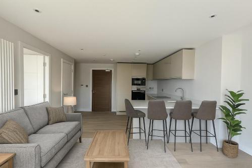 a living room and kitchen with a couch and a table at Paramount Stays - Uxbridge in Uxbridge