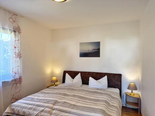 Un dormitorio con una cama con dos lámparas y una ventana. en Baltique - Ferienwohnung 2 Glowe, en Glowe