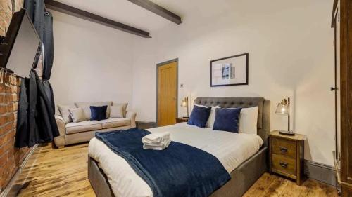 Un dormitorio con una cama grande y un sofá. en Bands Warehouse III Sleeping 8 Guests!, en Liverpool
