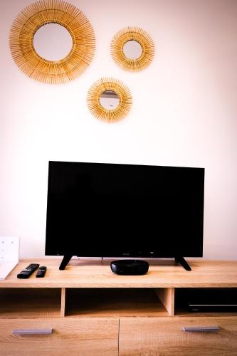 a flat screen tv sitting on top of a wooden table at La Villa Day **** in Les Cocos