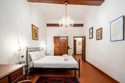 una camera da letto con un letto e un lampadario di 2BDR - Duomo & Uffizi - Chic Residence of the Cerchi by Hôtea a Firenze