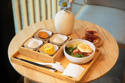 Una mesa con una bandeja de huevos y un tazón de comida. en Jingjie Garden Holiday Homestay, en Dali