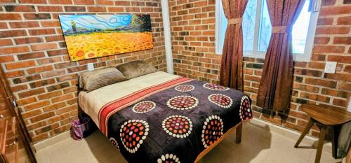 a bedroom with a bed in a brick wall at El Corazón de Villa in Villa del Carbón