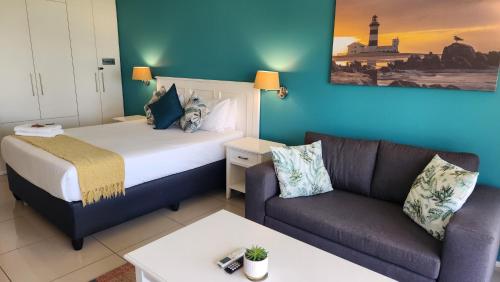 SummerstrandにあるSerenity at Brookes Hill Suitesのベッドとソファのあるホテルの部屋