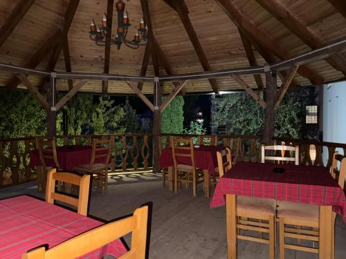 a restaurant with tables and chairs and a wooden ceiling at Kulla Emini Valbone 2025 in Valbonë