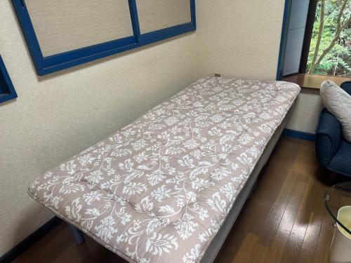 a bed in a room with a blanket on it at ホテル亀岡 in Minamijō