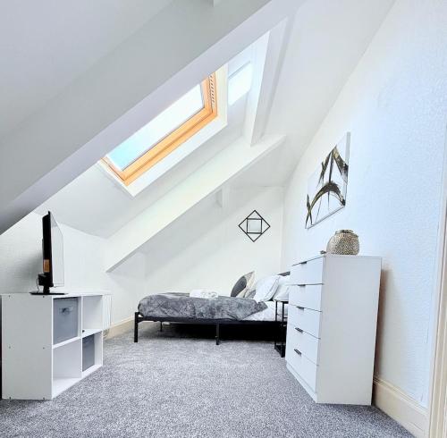 a white bedroom with a bed and a skylight at Spacious 4-Bedroom Newcastle, Sleeps 7 Guests in Kimbolton