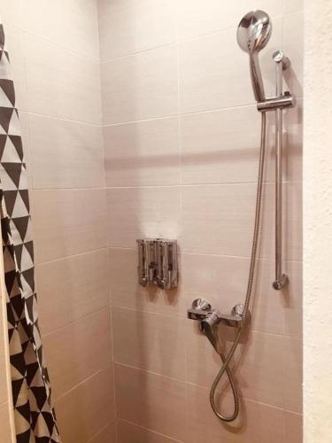 a shower with a shower head in a bathroom at Budget Rooms by LA88 in St. Paul's Bay