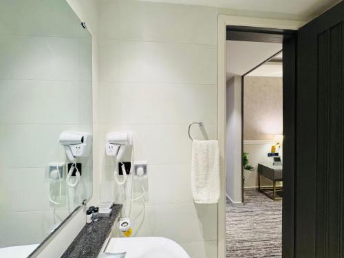 a bathroom with a sink and a mirror at Taj Hotel Suites F-7 Islamabad in Islamabad