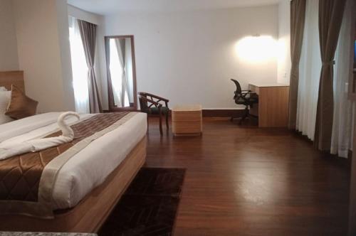 a hotel room with a bed and a desk at Hotel Arjay Valley, Pure Veg Luxury Hotel in Darjeeling