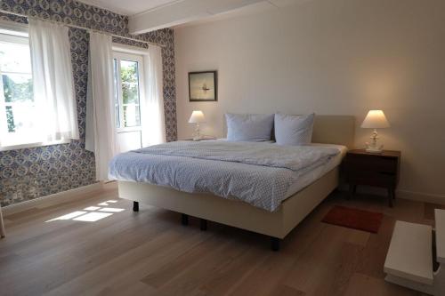 a bedroom with a bed with two lamps and a window at Welkimen tüs 1-Tradition in Oldsum