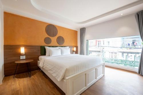 a bedroom with a white bed and a large window at La Hotel Nguyen Van Dung in Ho Chi Minh City
