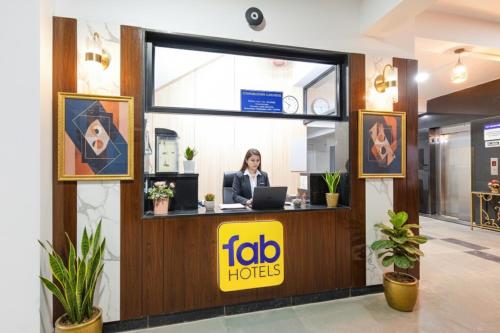 a woman sitting at a desk in a hotel lobby at FabHotel The Botanica- Nr Hmwssb Kondapur section office-Masjid Banda, Kondapur in Kondapur