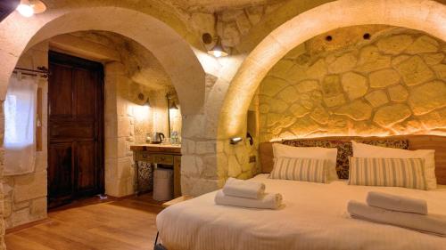 a bedroom with a large bed in a stone wall at Anjelic Cave Cappadocia in Urgup