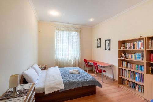 une chambre avec un lit, un bureau et une étagère dans l'établissement Vake Charm Residence, à Tbilissi