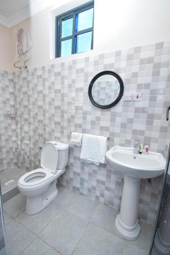 a bathroom with a toilet and a sink at Wayma Paradise Resort in Jambiani