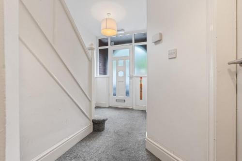 a hallway with white walls and a white door at 4-Bed Beeston Getaway - Free Parking in Beeston