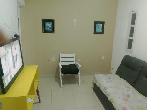 een woonkamer met een bank en een stoel bij Casas Mobiliadas in Aracaju