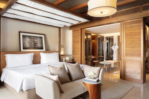 a bedroom with a white bed and a couch at Jumeirah Al Naseem Dubai in Dubai