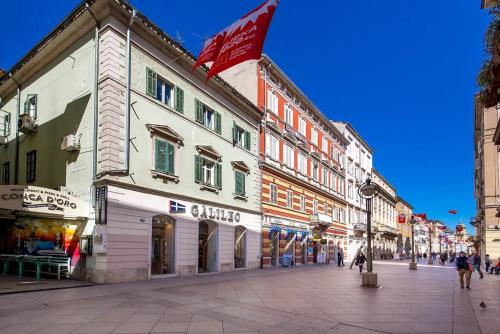 a street with buildings and people walking on a street at Four Seasons in Rijeka