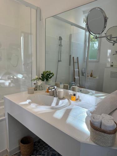 a white bathroom with a sink and a mirror at Villa Claudia Hotel Cannes Centre - Parking in Cannes
