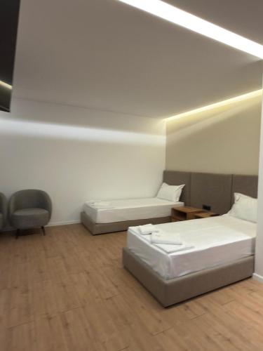 a room with two beds and a chair in it at Kulla Emini Valbone 2025 in Valbonë