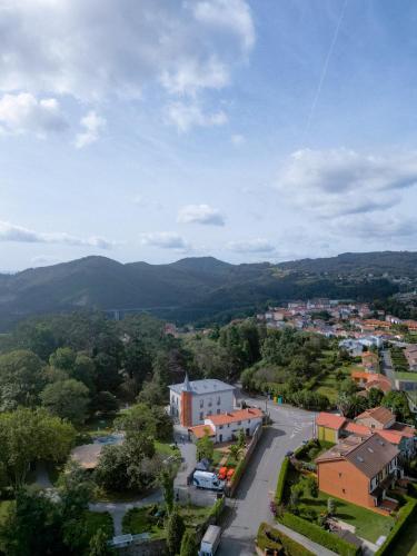 an aerial view of a town with mountains in the background at HOTEL BOUTIQUE VILLA DEL MARQUÉS in Muros de Nalón