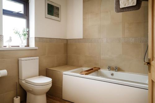 un baño con inodoro y bañera en Wheal Francis - Hot Tub - Accessible Bungalow - Free Wi-Fi - Parking, en Helston