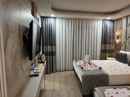 a hotel room with two beds and a television at Elysia Hotel in Istanbul