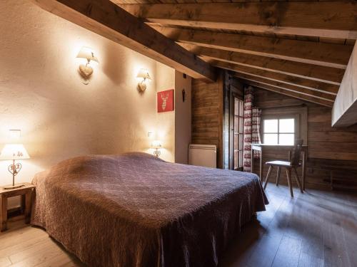 a bedroom with a large bed and a desk at Chalet pour 8 avec cheminée, proche des pistes, WiFi, garage, non fumeur - FR-1-304-110 in La Clusaz