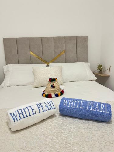 a bedroom with a bed with two pillows on it at Chauen White Pearl Apartments in Chefchaouene