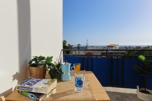 una mesa con libros y gafas en el balcón en Apartamento acogedor con vistas al mar, en Los Cristianos