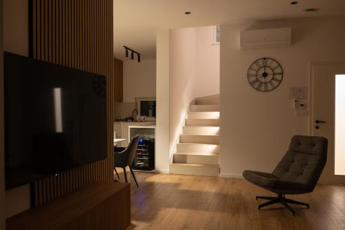 a living room with a television and a stair case at Apartment House AGAPE in Kerestinec