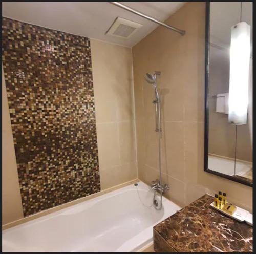 a bathroom with a shower and a tub and a sink at Admiral Premier Bangkok in Bangkok