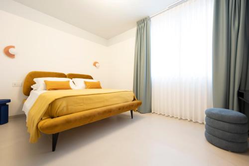 a bedroom with a bed with a yellow blanket at In Piazza BnB in San Salvo