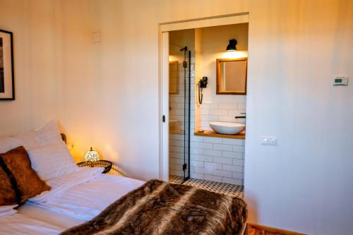 a bedroom with a bed and a bathroom with a sink at Ugron Castle Fiatfalva in Cristuru Secuiesc