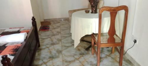 a wooden chair in a room with a table at Gorilla African Guest House in Entebbe