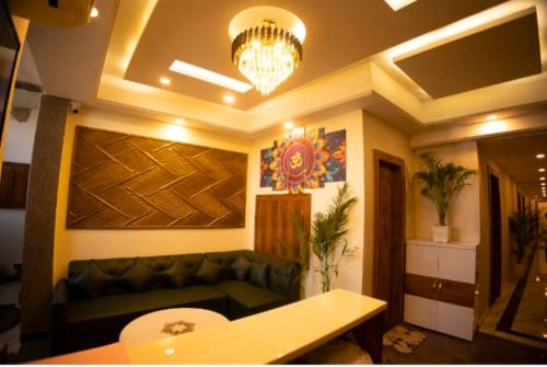 a living room with a couch and a chandelier at Hotel Rajshree in Kurukshetra