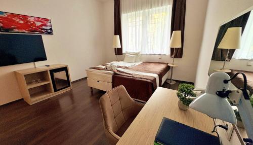 a small room with a bed and a table at Hotel Opal Superior - Adults Only in Gyöngyös
