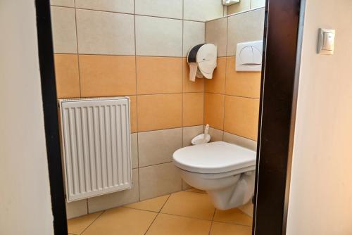 a small bathroom with a toilet and a radiator at Hotel Opal Superior - Adults Only in Gyöngyös