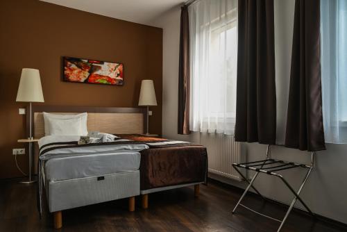 a bedroom with a bed and a window at Hotel Opal Superior - Adults Only in Gyöngyös