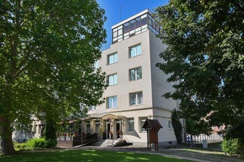 a tall white building with stairs in front of it at Hotel Opal Superior - Adults Only in Gyöngyös