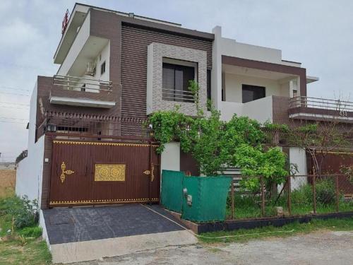 a house with a gate and a fence at Airways B&B Islamabad Free Airport Pick and Drop in Islamabad