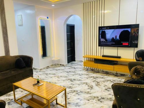 a living room with a tv and a coffee table at Spectacular 3/4-Bed-Apt With 24hrs Power And FAST Wi-Fi in Amuwo