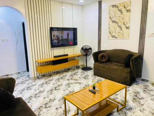 a living room with two couches and a television at Spectacular 3/4-Bed-Apt With 24hrs Power And FAST Wi-Fi in Amuwo