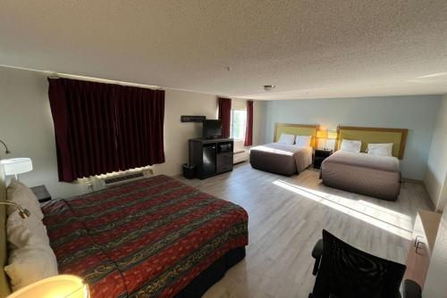 Una habitación de hotel con dos camas y un televisor. en Coratel Inn and Suites by Jasper Wesley Hospital, en Wichita