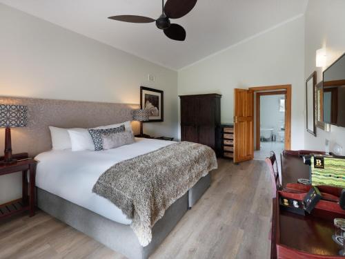 a bedroom with a bed and a ceiling fan at ANEW Resort Ingeli Forest Kokstad in Kokstad